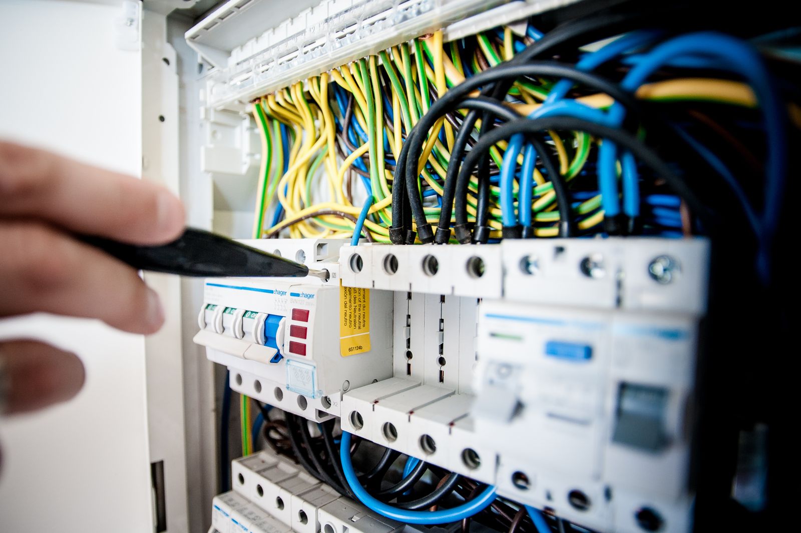Close-up of DIN rail circuit breakers and earth wiring in a switchboard